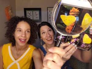 People examining butterfly images through a magnifying glass during an educational activity