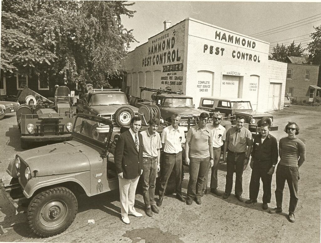 A group of men specializing in pest control for South Chicago suburbs stand in front of a building.
