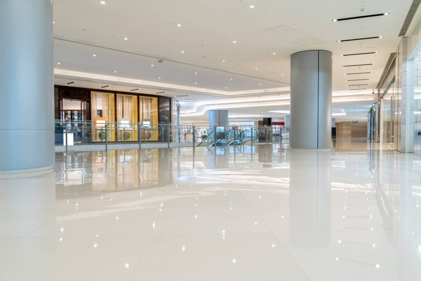 Spacious modern shopping mall interior with polished floors and escalators<br />
